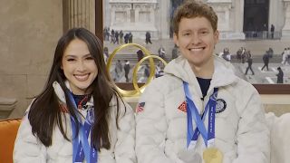 Olympic Ice Dancers Madison Chock and Evan Bates smiling on the Today Show wearing their Olympic medals