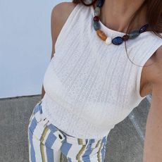 @jen_wonders selfie closeup featuring colorful beaded necklace and cream knit tank