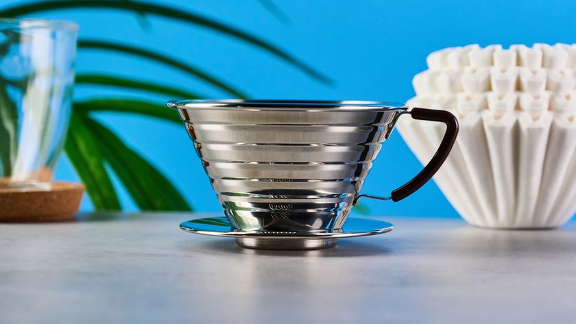 kalita wave stainless steel pour-over coffee dripper photographed against a blue background with kalita filters