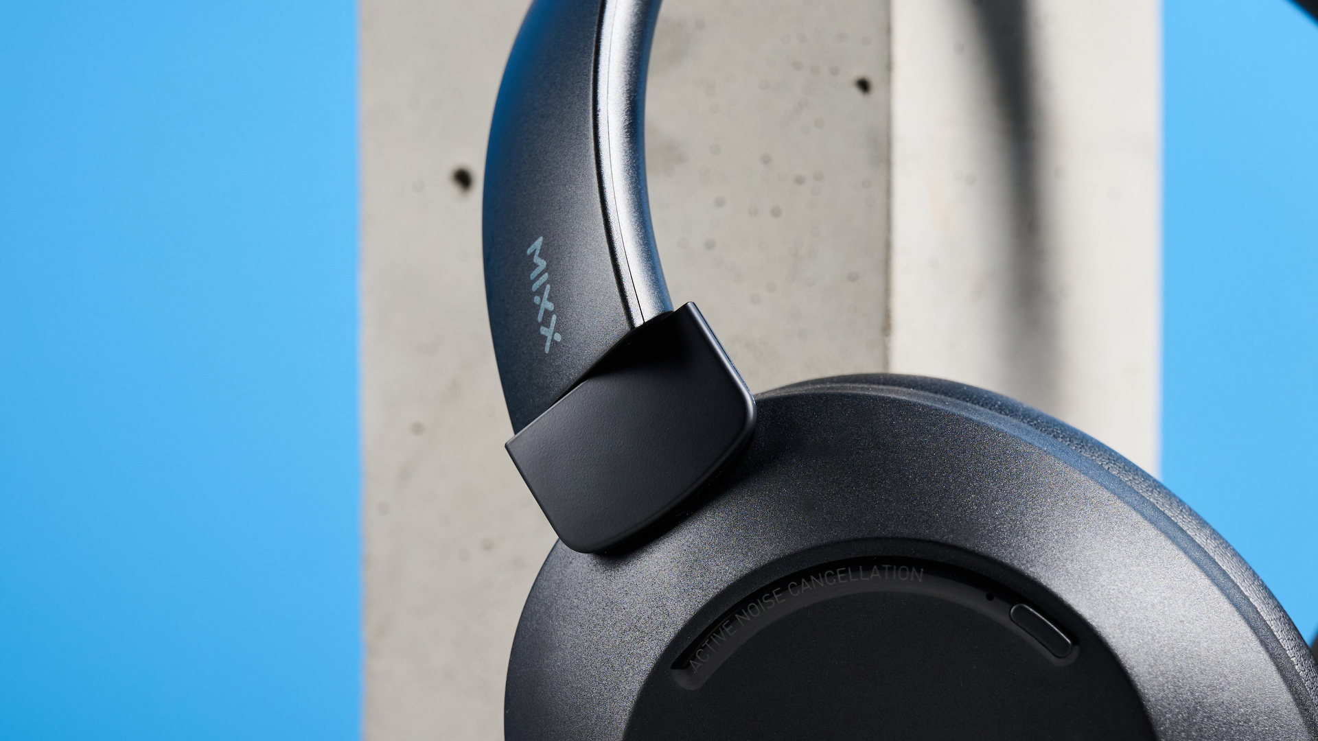 the mixx streamq c4 headphones in black with a blue background showing the soft cups and buttons controls