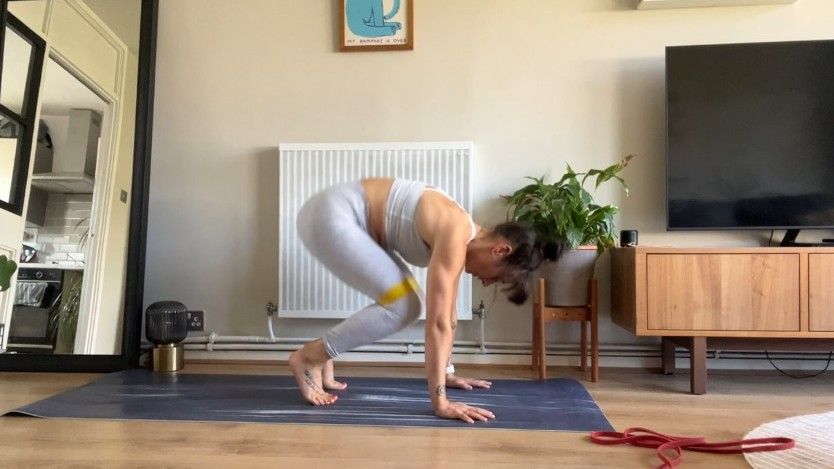 Writer Sam performing plank tuck jumping forward on mat during home ab workout