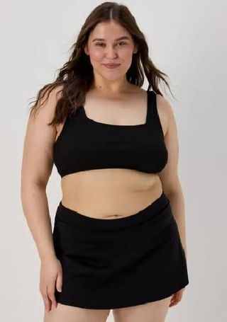 A plus size model wearing a black bikini and bikini skirt from Matalan. 