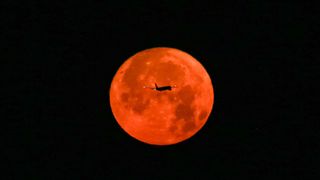 The full moon is pictured with an airplane on July 03, 2023 in Istanbul, Türkiye.