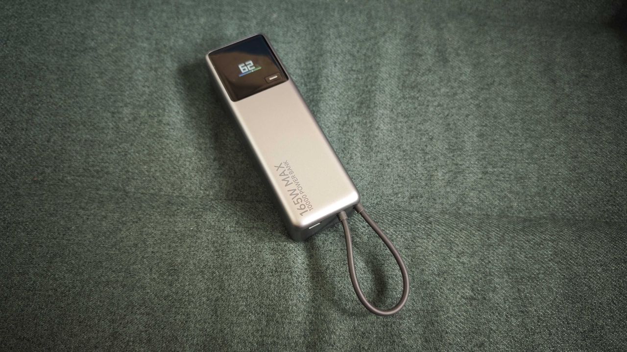 A matte grey Xiaomi 165W Power Bank on a green sofa