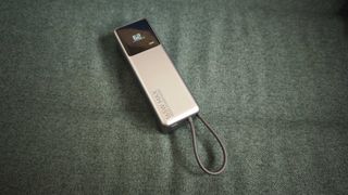 A matte grey Xiaomi 165W Power Bank on a green sofa