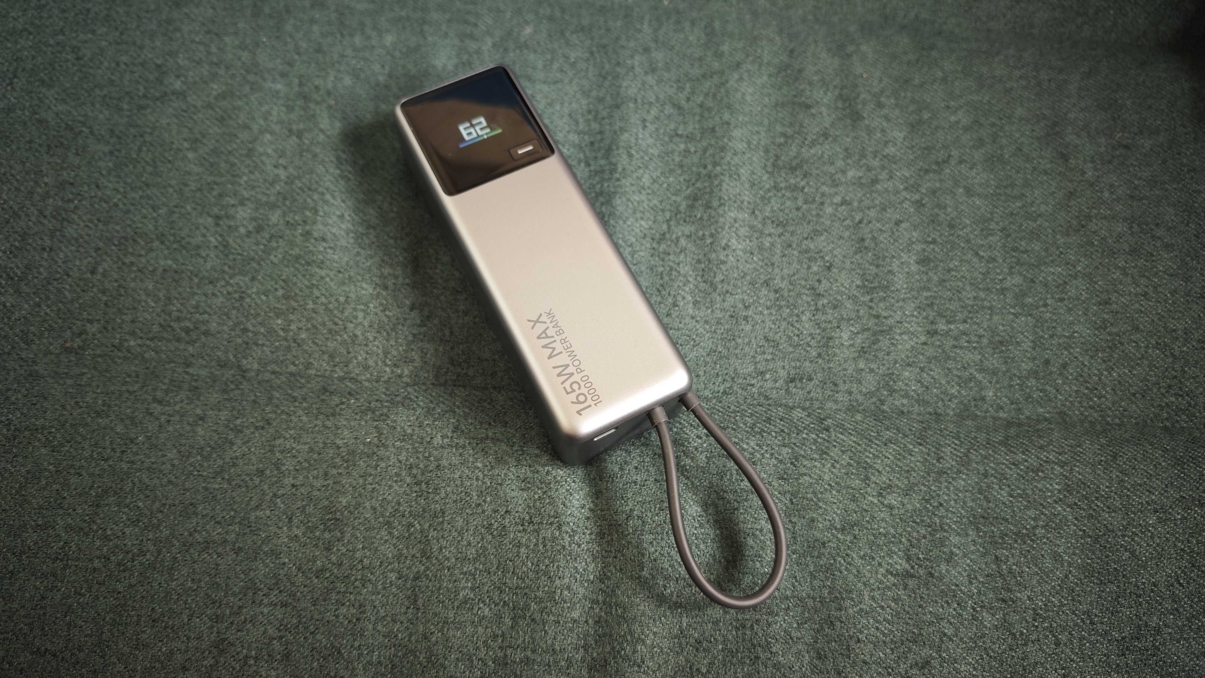 A matte grey Xiaomi 165W Power Bank on a green sofa
