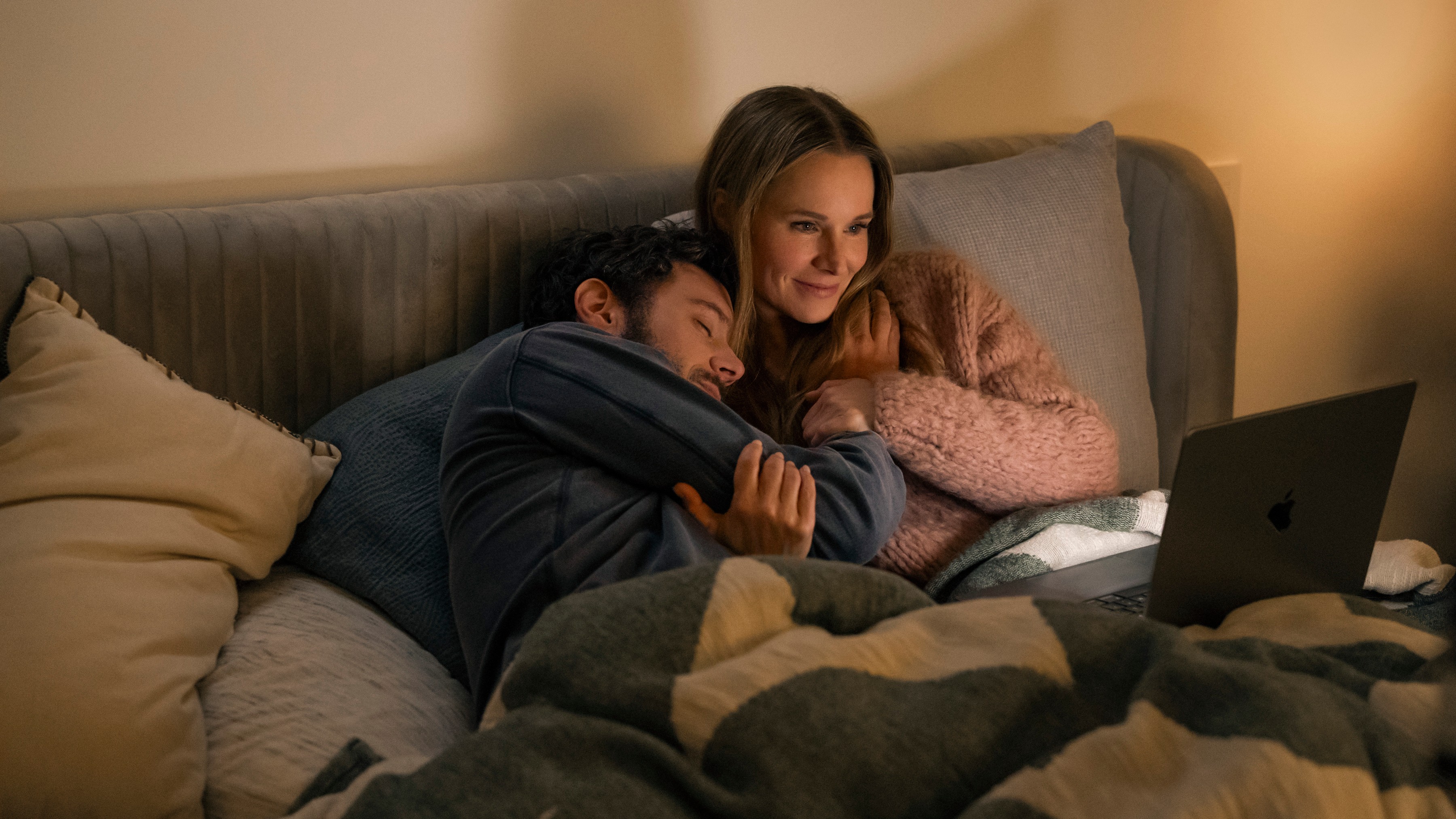 L-R: Noah (Adam Brody) and Joanne (Kristen Bell) cuddle in bed in a scene from "Nobody Wants This" season 2