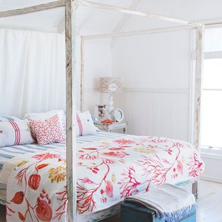 summer bedroom with floral bedding and four poster bed