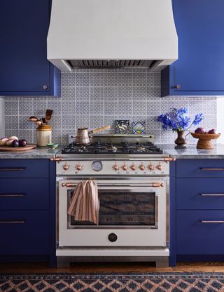 An electric blue kitchen shot of white oven as the centrepiece and copper details