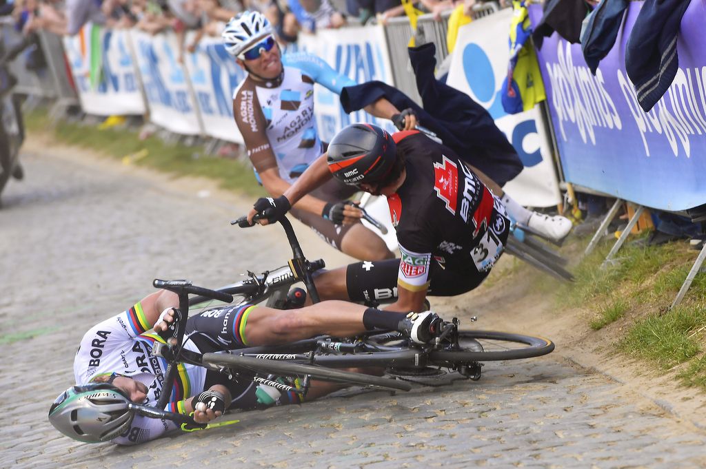 Sagan hits the ground hard as Greg Van Avermaet twists in the crash