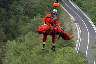 A rescue worker and Pedro Horrillo (Rabobank) are lifted into the helicopter which will transport the Spanish rider to a hospital after his serious accident on stage eight.