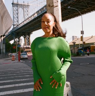 Orion Pictures president Alana Mayo wears a green sweater dress while posing in front of a New York City intersection.