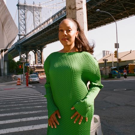 Orion Pictures president Alana Mayo wears a green sweater dress while posing in front of a New York City intersection.