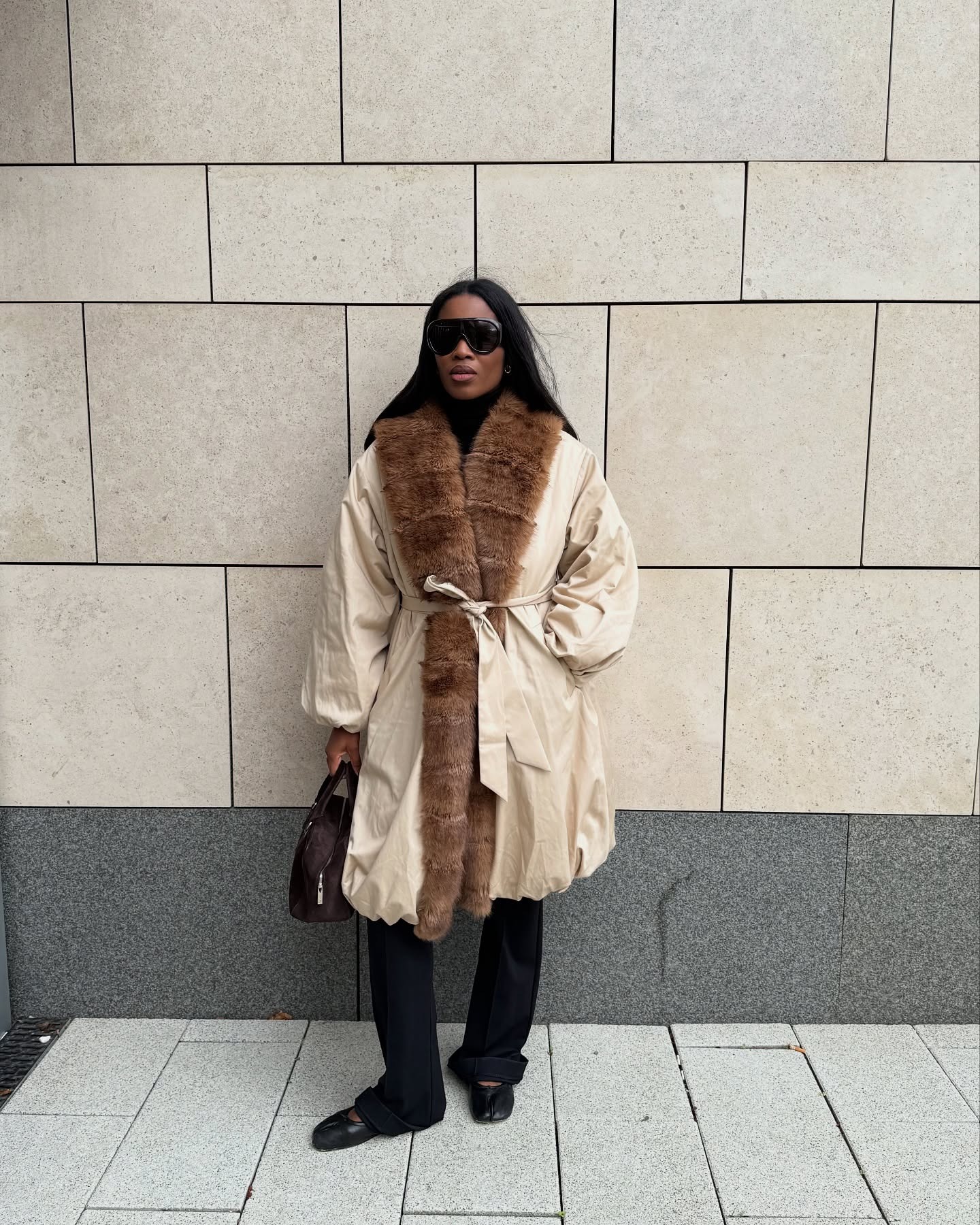 British fashion influencer @nlmarilyn wearing a fur-trimmed coat with black pants and black Tabi ballet flats