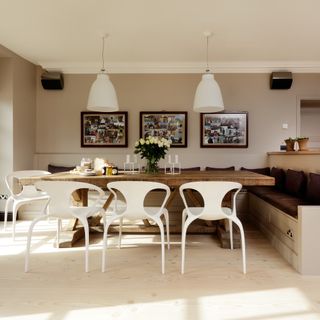 beige kitchen with table, white chairs and pictures