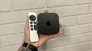 Apple TV 4K and remote in the hand