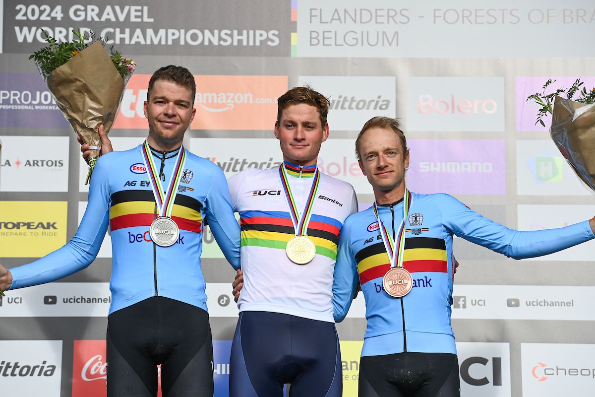 Picture by Simon Wilkinson/SWpix.com - 06/10/2024 - Cycling - 2024 UCI Gravel World Championships, Halle-Leuven, Belgium - Men Elite Race Podium - Mathieu Van der Poel (Netherlands) on the podium receiving the Gold Medal and World Champions Jersey with Florian Vermeersch (Belgium) receiving the Silver Medal and Quinten Hermans (Belgium) receiving the Bronze Medal
