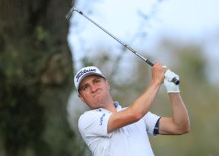 Justin Thomas watches his wedge shot