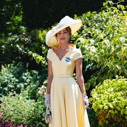 Lydia Millen in a large hat smiling in a garden