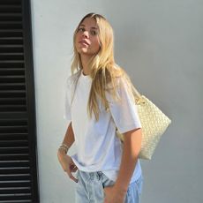 sofia richie in a white t-shirt and woven bottega veneta bag