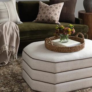 A geometric white ottoman from McGee & Co. with a tray of accessories on top
