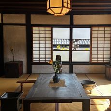 a japanese apartment with a large window and a wooden table and chairs