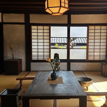 a japanese apartment with a large window and a wooden table and chairs