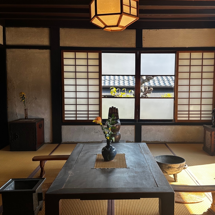 a japanese apartment with a large window and a wooden table and chairs