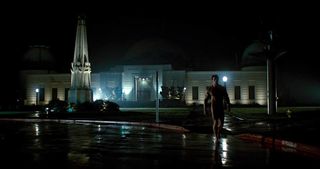 a naked man walking in front of the Griffith Observatory