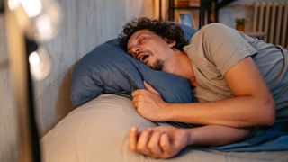 A person lying in bed, snoring