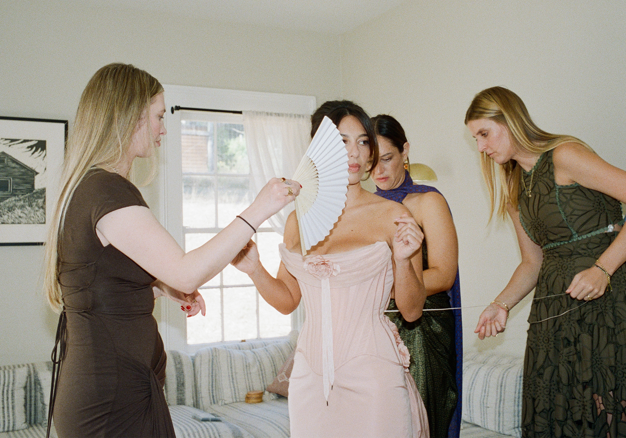 Hadley getting her dress tied by her friends.