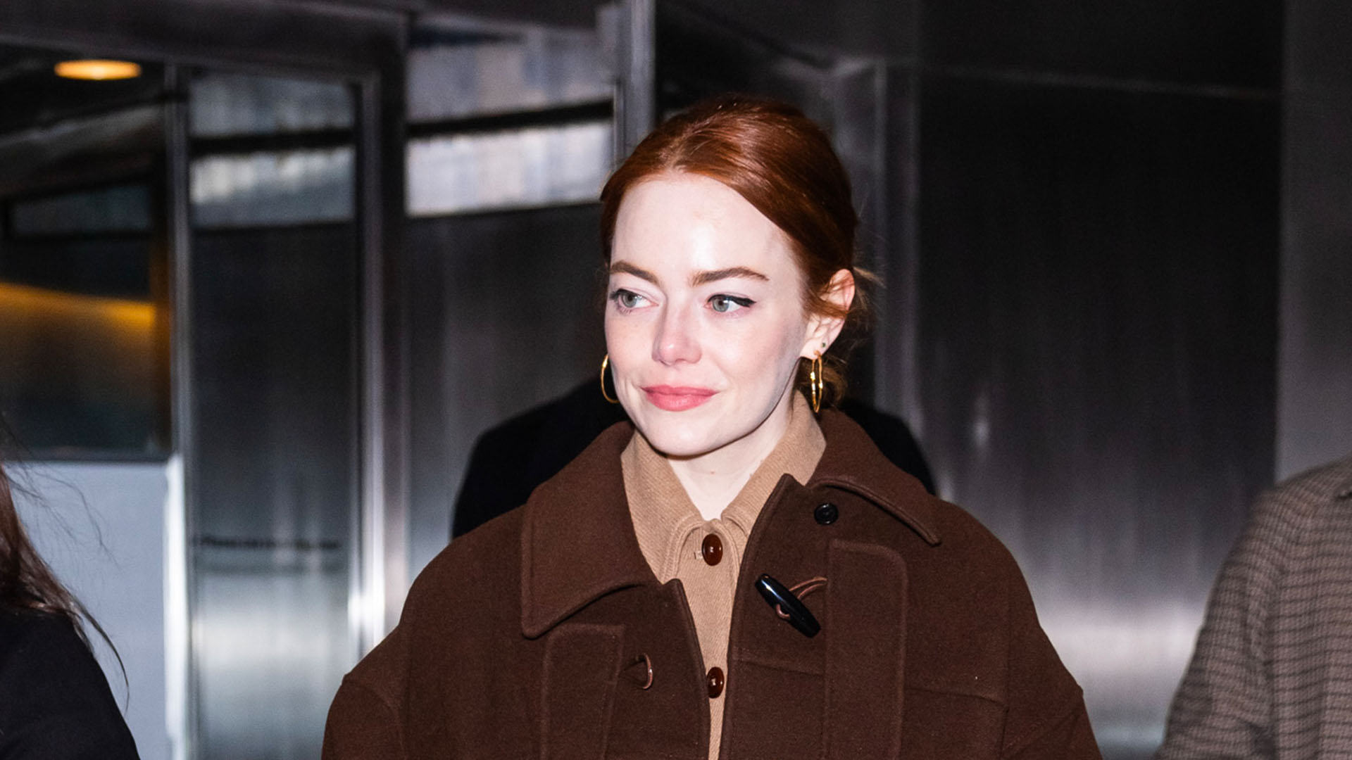 Emma Stone wearing a brown coat