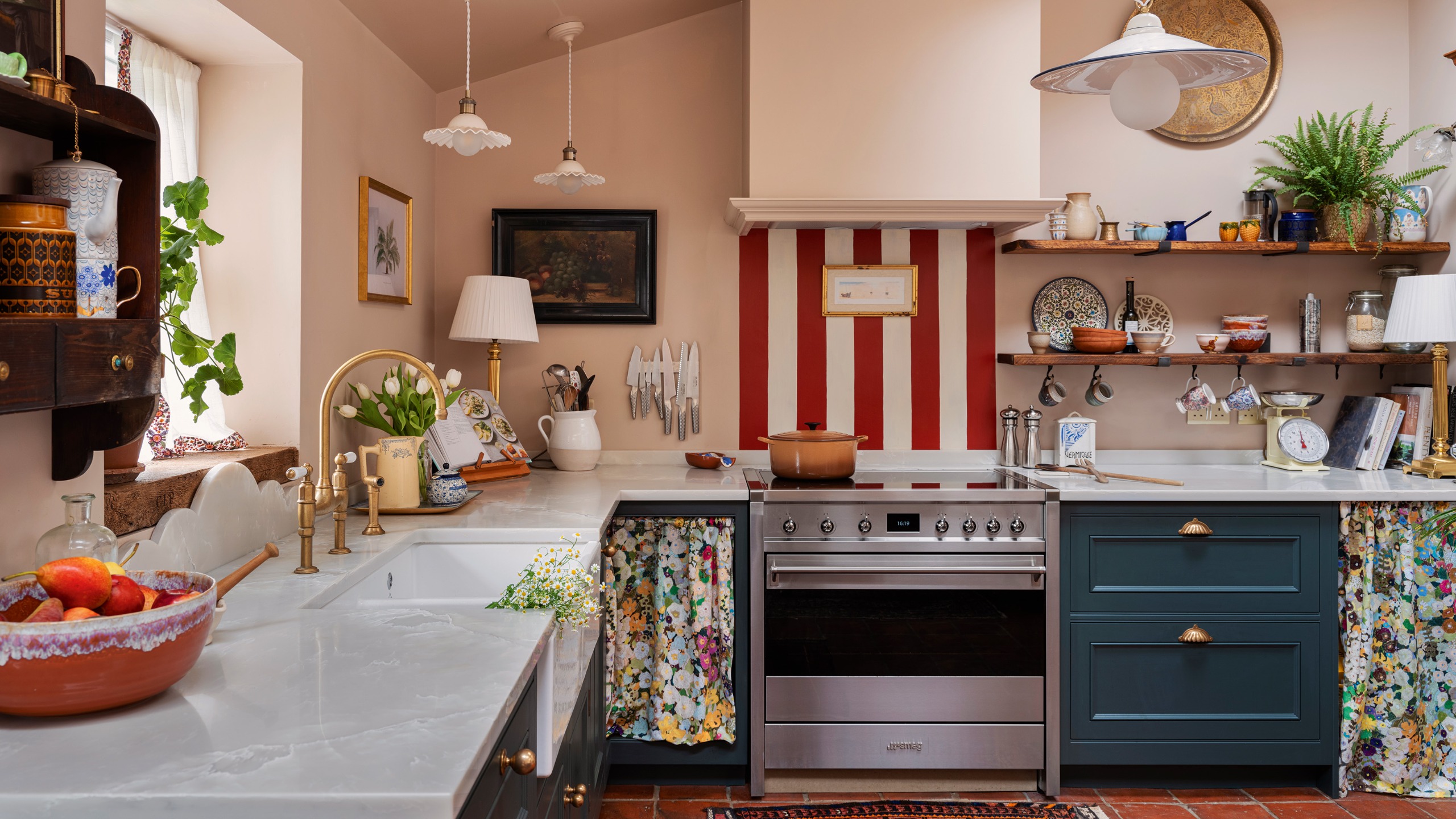 vintage inspired kitchen with red and white splashback blue cabinetry and antique wooden furniture