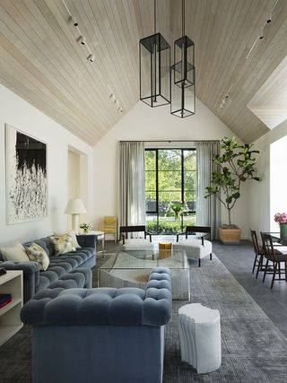 transitional style living room with large windows and big ceiling lights