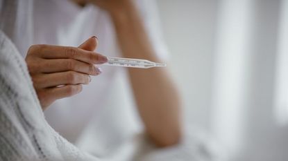 Woman Holding Thermometer