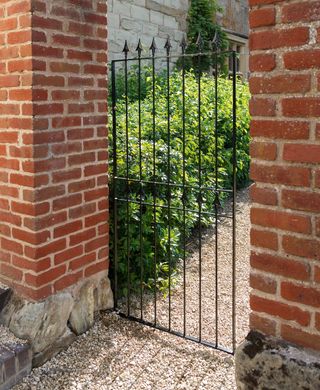 Spear top wrought iron gate in brick wall