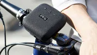 The Tribit StormBox Micro strapped onto a bike handle