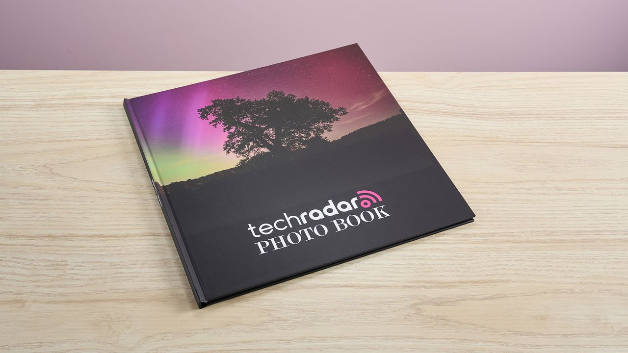 The Mixbook photo book sits on a light wooden surface.