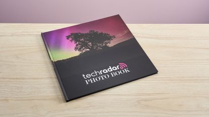 The Mixbook photo book sits on a light wooden surface.