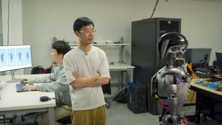 Nvidia employee next to AI robot in lab