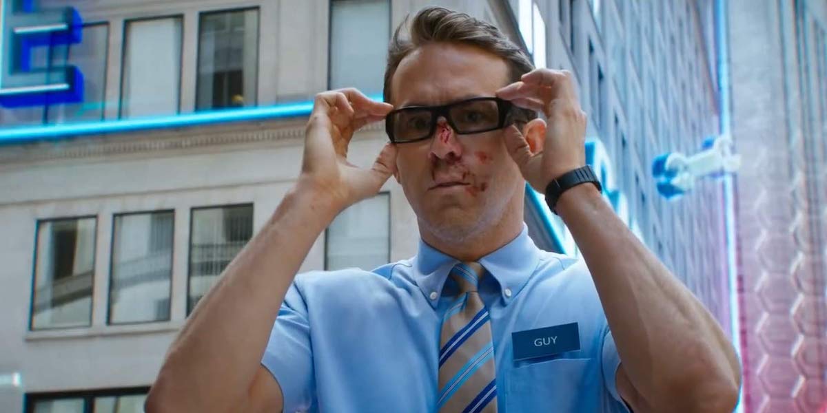 Guy (Ryan Reynolds) has a bloody face as he puts on his glasses in &#039;Free Guy.&#039;