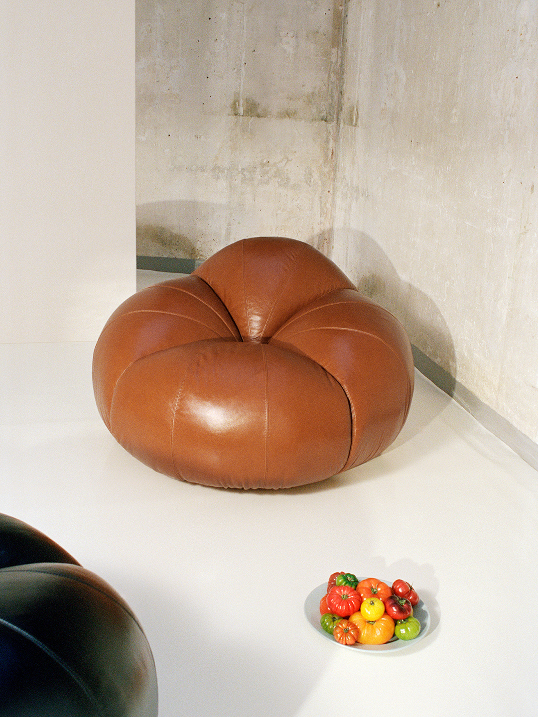 A tan coloured leather chair in the shape of a Tomato, designed by Chlo&amp;eacute;.