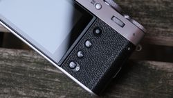Fujifilm X100VI camera close up of the screen and buttons, sat on on a slatted wooden bench