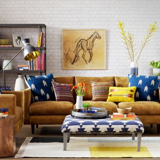 living room with yellow sofa white brick wall and wooden flooring