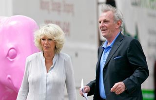 Duchess Camilla of Cornwall talks with her brother Mark Shand as he gives her a tour of the Elephant Parade at The Royal Hospital, Chelsea on June 24, 2010 in London, England