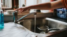 picture of woman running tap of kitchen sink