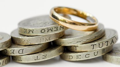 Wedding ring on pile of coins