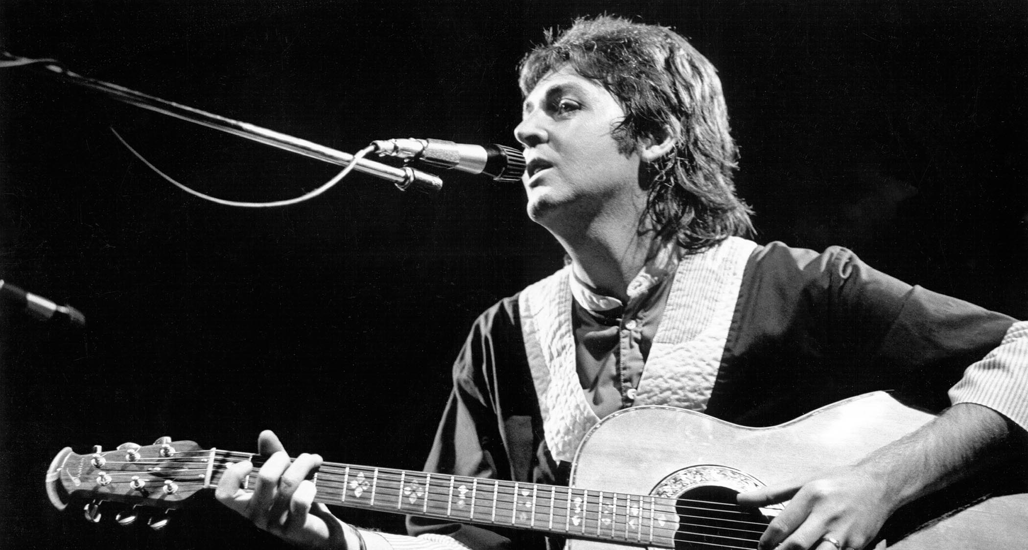 Paul McCartney plays an Ovation acoustic onstage with Wings.