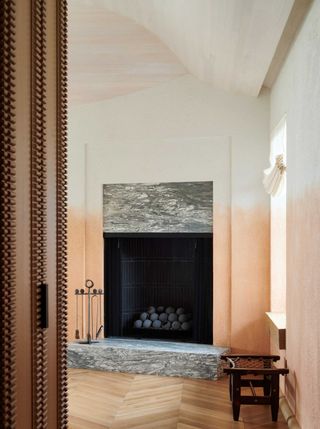 a marble fireplace in a room with ombre walls
