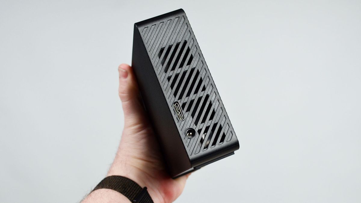 A masculine hand holding a Seagate Expansion external desktop hard drive